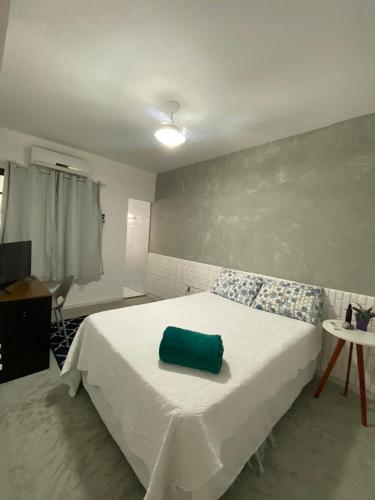 a bedroom with a bed with a green bag on it at Suítes Vilas do atlântico a 100M da praia in Lauro de Freitas