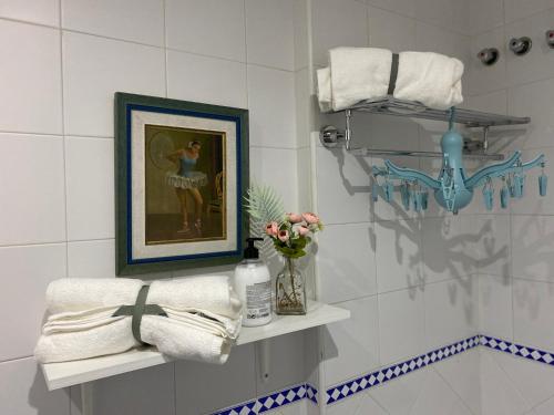 une salle de bains avec une peinture d'une femme sur le mur dans l'établissement AljaLux Sevilla Bormujos, à Bormujos