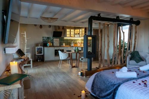 Domaine de la Baie de Somme, suite Vanadis في كايو سور مير: غرفة نوم بسرير ومطبخ مع طاولة
