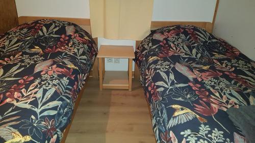 een paar bedden in een kamer met een tafel bij chalet tout équipé in Signy-le-Petit