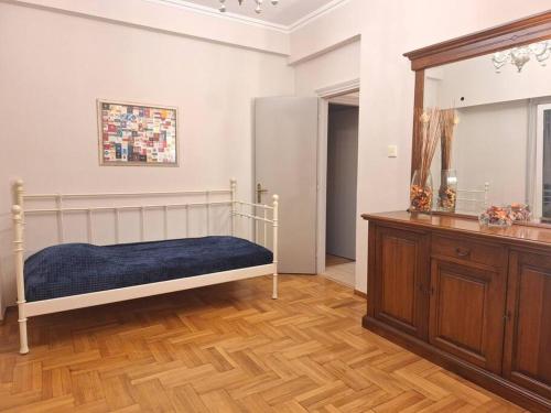 a bedroom with a bed and a dresser and a mirror at Cozy apartment next to metro station in Athens