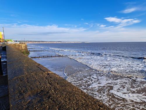 a beach with a pier and the ocean at Beach 100m - Sea View - Log Burner - Dogs Welcome in Bessingby