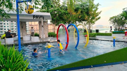 two children playing in the water in a pool at Ocean Home@Urban Suites@12 Pax in Jelutong
