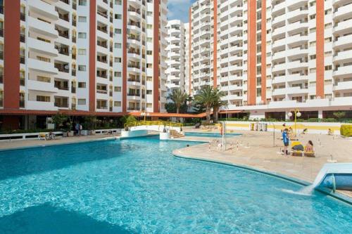 a swimming pool in front of some tall buildings at Rocha Oceanside by CC 925 in Portimão