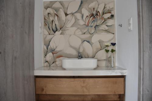 un bagno con lavandino e parete floreale di Elean a Kavoúsion