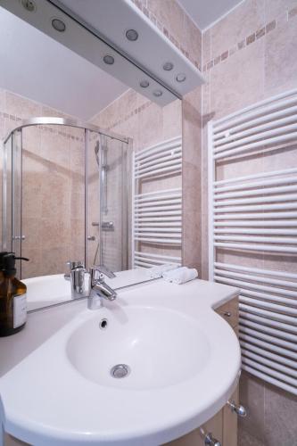 une salle de bain avec un lavabo blanc et un miroir dans l'établissement La Petite Venise, à Grimaud