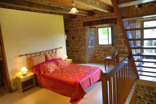 - une chambre avec un lit rouge et un escalier dans l'établissement Gîte de la Capelle, à Florentin-la-Capelle