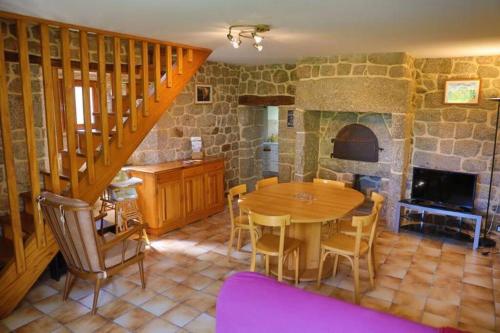eine Küche und ein Esszimmer mit einem Tisch und einem Kamin in der Unterkunft Gîte de la Capelle in Florentin-la-Capelle