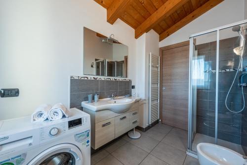 y baño con lavadora y lavamanos. en In Piazzetta holiday apartments, Barolo, en Barolo