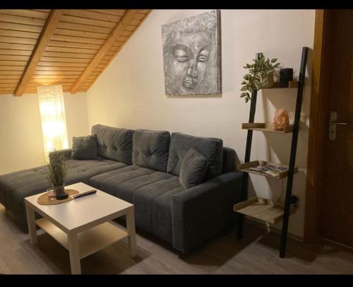 uma sala de estar com um sofá e uma mesa em Ferienwohnung Fischer in Rödental em Rödental