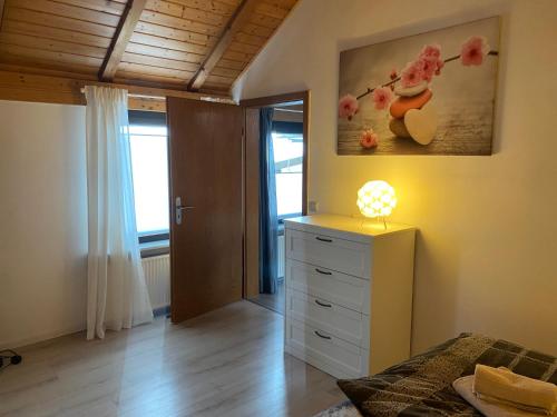 a bedroom with a bed and a dresser with a lamp at Ferienwohnung Fischer in Rödental in Rödental