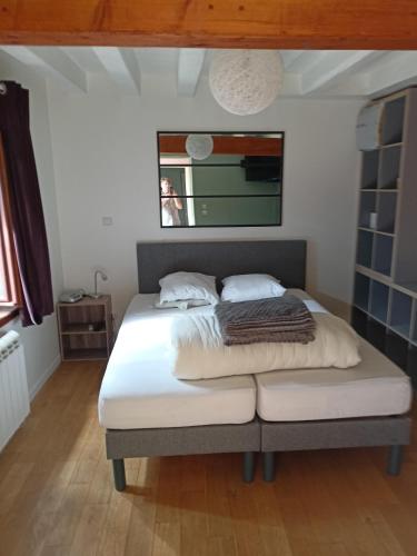 um quarto com uma cama com lençóis brancos e uma janela em Chambres d hôtes entrée+sanitaires indépendantes em Thorigné-sur-Dué