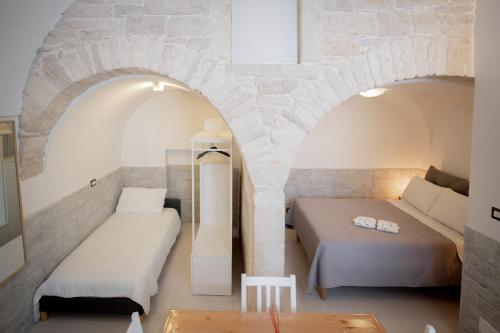 2 camas en una habitación con una pared de piedra en La Casa di Saretta, en Terlizzi