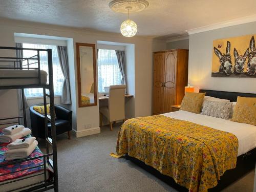 a bedroom with a bunk bed and a desk at Babbacombe Palms in Torquay