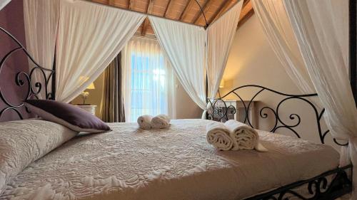 una camera da letto con un letto e asciugamani di Borgo del Silenzio - Apartments with pool in Lajatico a Laiatico