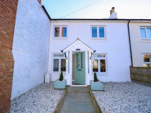 a white house with a green door at 1 Star Cottages in Freshwater