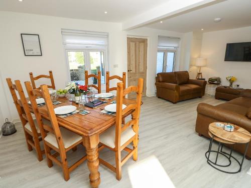 a dining room and living room with a table and chairs at 1 Star Cottages in Freshwater