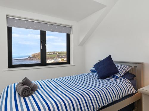 Un dormitorio con una cama con vistas a la playa. en One Sand Banks, en Haverfordwest