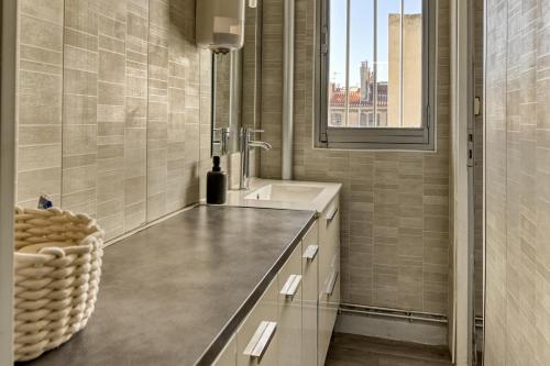 une salle de bain avec un lavabo, un miroir et une fenêtre dans l'établissement NOCNOC Le Capucin, à Marseille