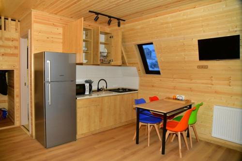 古道里的住宿－Kai cottage，厨房配有桌椅和冰箱。