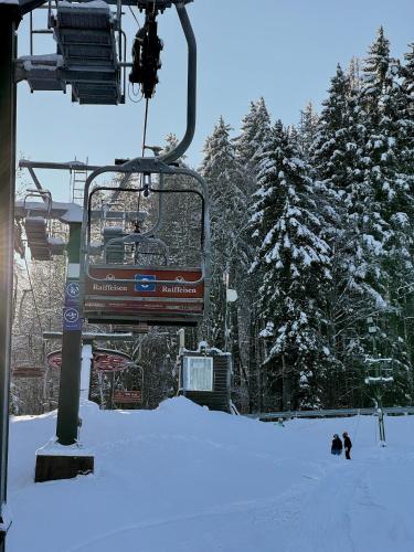 a ski lift with people on it in the snow at Apartmány Havířská Žacléř, Krkonoše in Žacléř