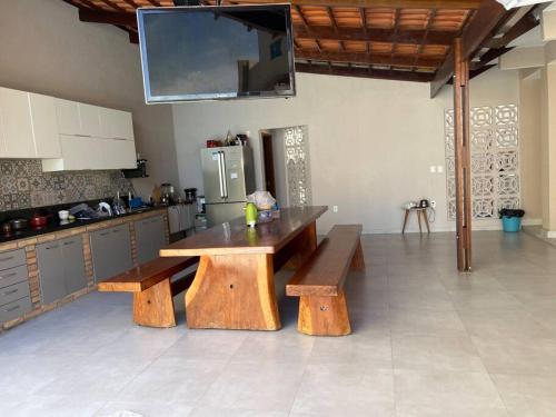 une cuisine avec une table en bois et deux bancs dans l'établissement Casa Recanto dos Pássaros, à Marechal Deodoro