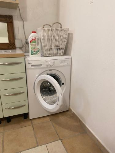 een wasmachine met een mand erop bij Porto Cesareo - Appartamento località Torre Lapillo - Orione C10 in Torre Lapillo