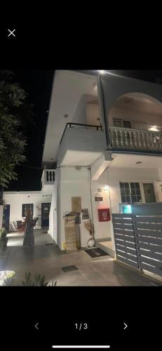 a woman standing in front of a white building at Afroditi Junior Suites in Archangelos
