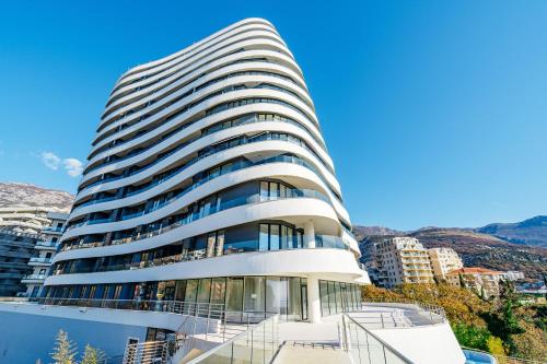 un edificio alto de color blanco con ventanas de cristal en Skyline Apartments by In Property en Bečići