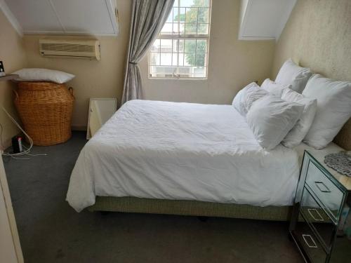 a bedroom with a bed with white sheets and pillows at Neatly Furnished Apartment in Mataffin