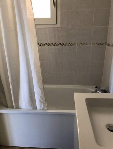 une salle de bain avec un rideau de douche et un lavabo dans l'établissement Maisonnette les Marines d'Helios T2 cabine, à Marseillan