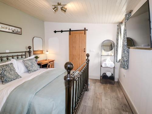 a bedroom with a bed and a wooden floor at The Shearer's Hut in Holmfirth