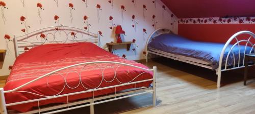 sypialnia z 2 łóżkami i ścianą z kwiatami w obiekcie Les Chambres du Relais w mieście Liettres