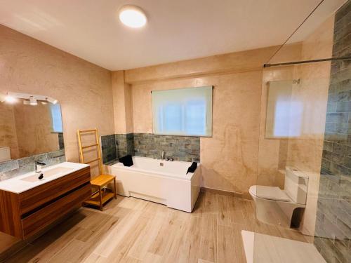 een badkamer met een bad, een wastafel en een toilet bij Cherry JACUZZI Apartment in Ronda