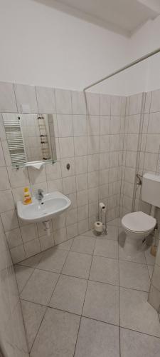 y baño con lavabo y aseo. en Csata Vendéglő és Panzió, en Isaszeg