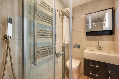 a bathroom with a shower and a toilet and a sink at Luxury Apartments Victoria, London Eye, Big Ben in London