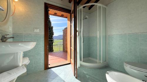 bagno con doccia, lavandino e servizi igienici di Borgo del Silenzio - Apartments with pool in Lajatico a Laiatico