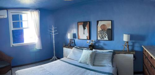 a blue bedroom with a bed with blue walls at Pousada dos Gravatás in Búzios