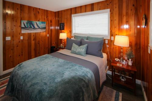 a bedroom with a bed and wood paneled walls at Ocean View Retreat in Brookings