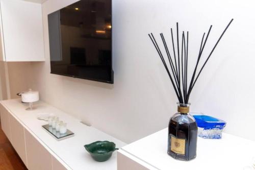 a vase with sticks in it sitting on a counter at La Dimora del Benessere in Noicattaro