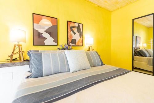 a bedroom with a large bed with yellow walls at Pousada dos Gravatás in Búzios