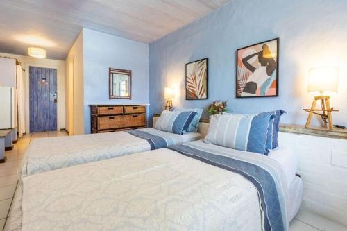 two beds in a bedroom with blue walls at Pousada dos Gravatás in Búzios