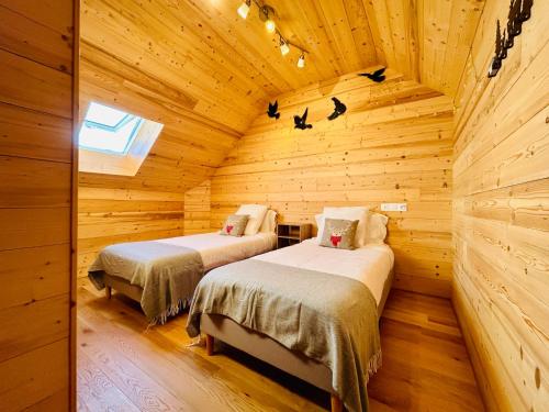 1 dormitorio con 2 camas en una cabaña de madera en Au Pied de l'Arcluse, terrasses et jardin - CLG - Savoie Bauges - 2 CH, en Chevillard