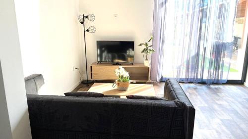 sala de estar con sofá negro y mesa en Superbe appartement classé 4 étoiles - le Boulou, en Le Boulou
