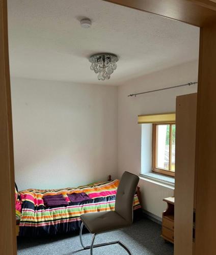 sypialnia z łóżkiem, krzesłem i oknem w obiekcie Ganzes Haus in der Natur w mieście Lauingen