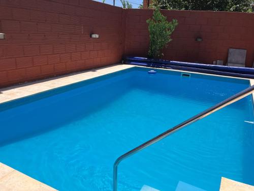 an empty swimming pool with a red brick wall at Casa quinta El Descanso in General Rodríguez