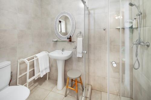 La salle de bains est pourvue d'un lavabo, d'une douche et de toilettes. dans l'établissement Summer Place Guest House, à Port Edward