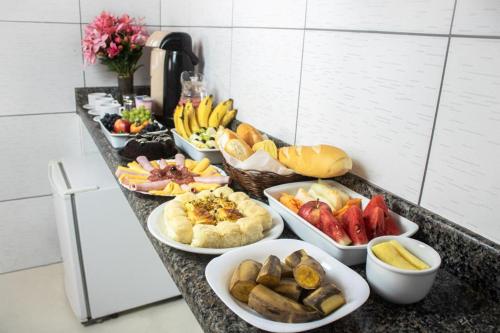 un buffet de diferentes tipos de comida en un mostrador en Hotel Atlanta, en Salvador