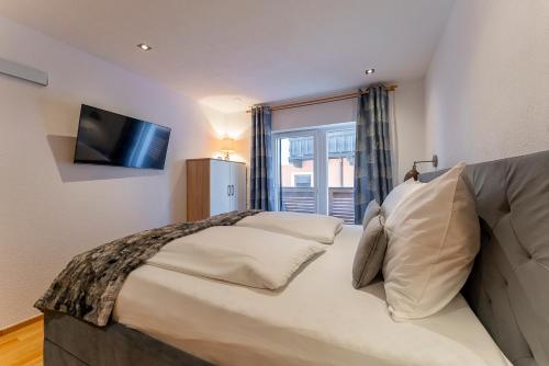 - une chambre avec un grand lit et une télévision dans l'établissement Apartment Piesendorf, à Piesendorf