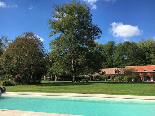 uma piscina em frente a uma casa com uma árvore em Domaine de Montizeau em Lailly-en-Val
